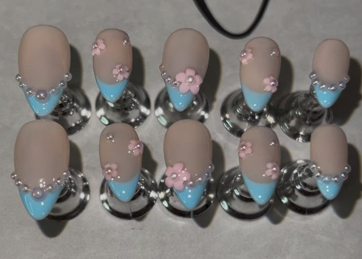 Short almond with blue french tips with floral design.